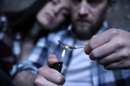 couple heating heroin spoon