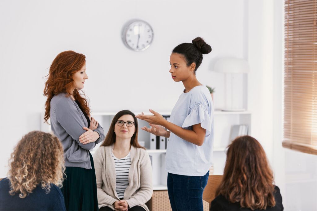 Two women talking to each other in a group